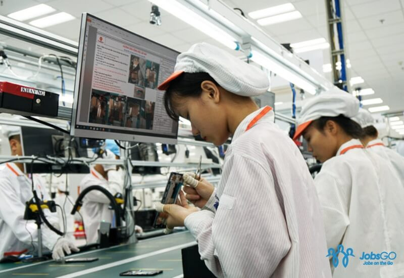 Kỹ thuật viên SMT đang làm việc trong môi trường sản xuất điện tử chuyên nghiệp