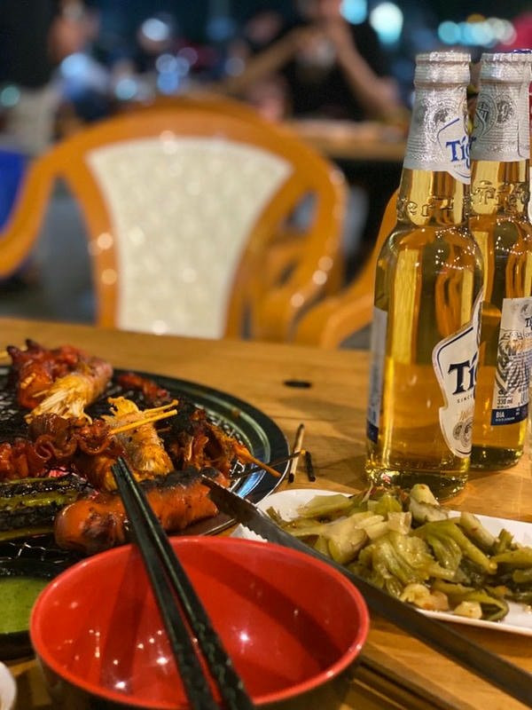Cô gái trẻ ngồi nhậu một mình trong quán vắng, ánh mắt xa xăm nhìn ra cửa sổ, gợi cảm giác suy tư.