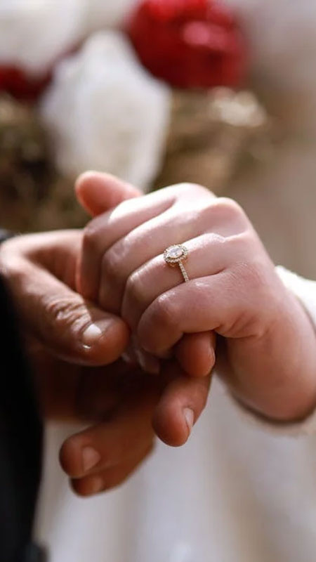 Hình ảnh hai bàn tay đeo nhẫn cưới nắm chặt, thể hiện tình yêu và sự cam kết