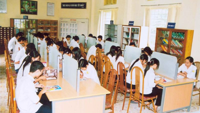 Sân trường rộng với cột cờ và các dãy nhà
